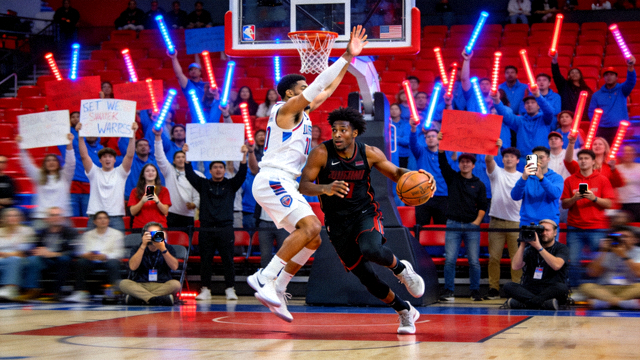NBA总决赛比赛现场图，球员在篮下激烈对抗并有观众席背景